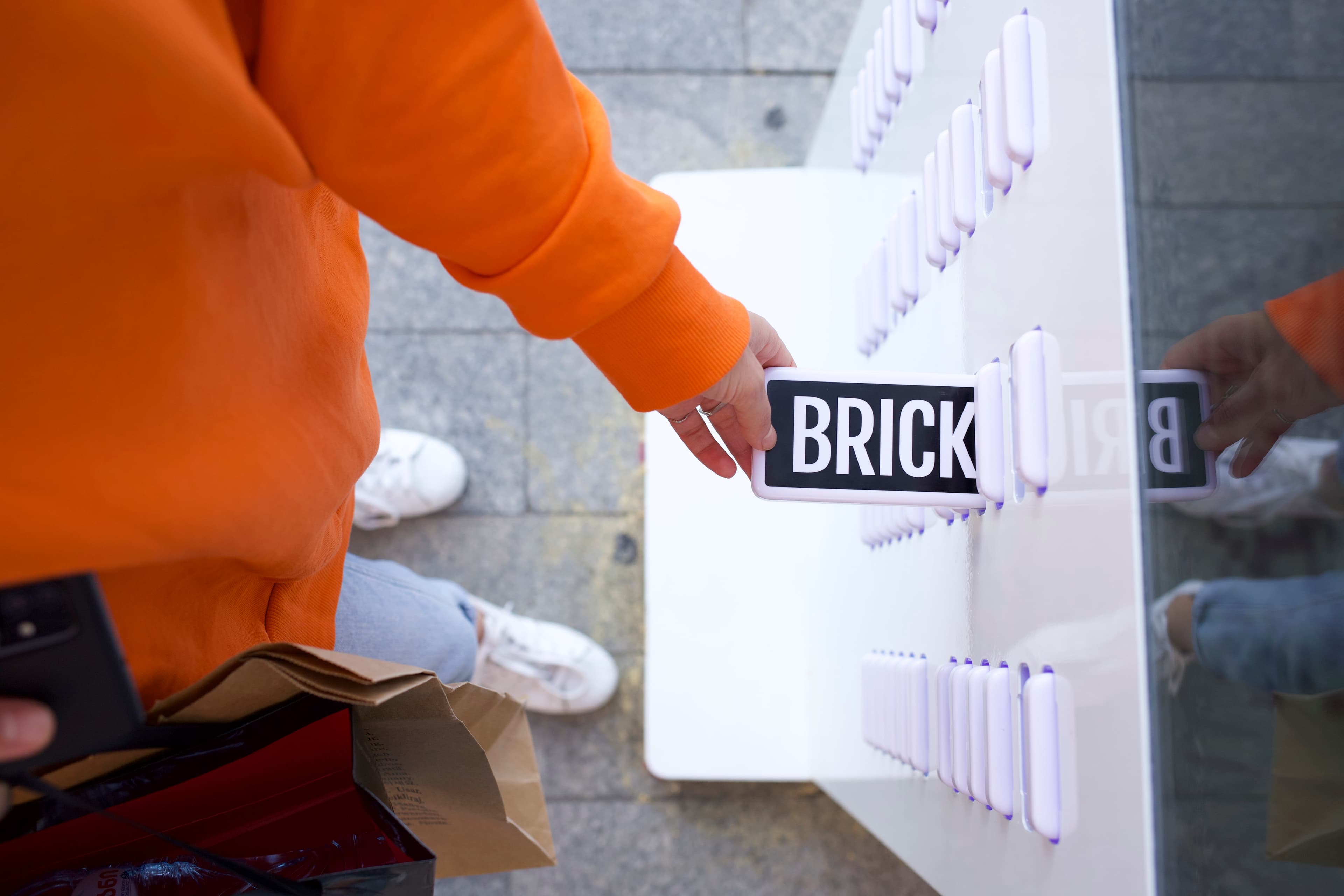 Ręka odbierająca power bank Brick ze stacji